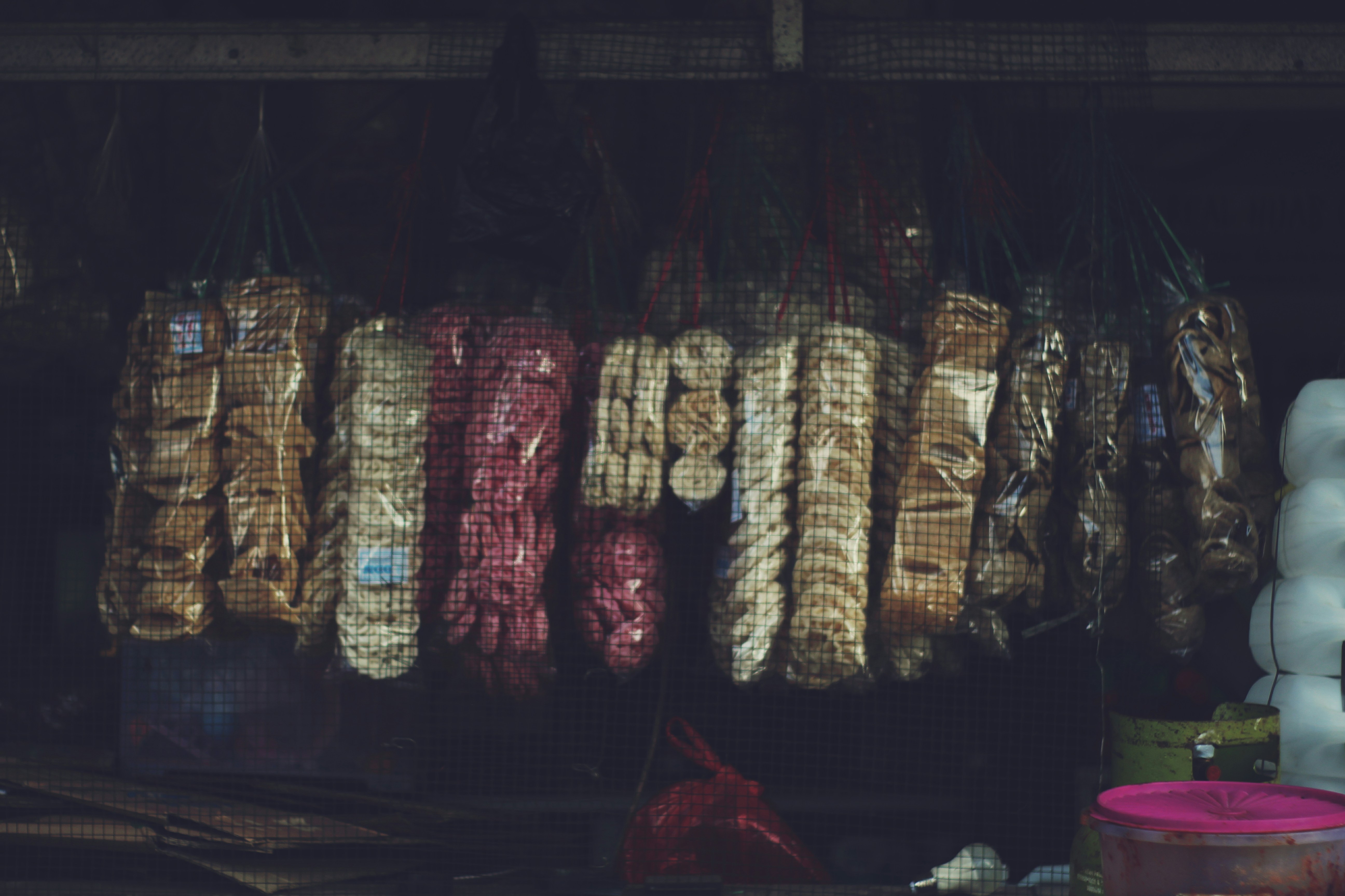 there are many bags of food hanging on a rack