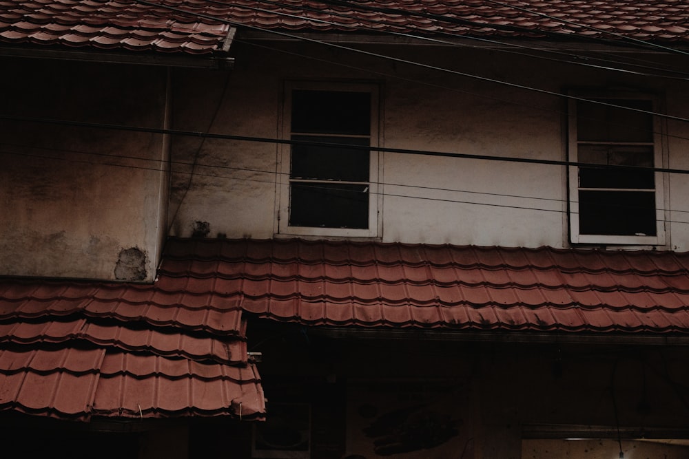 a building with a red tiled roof and two windows