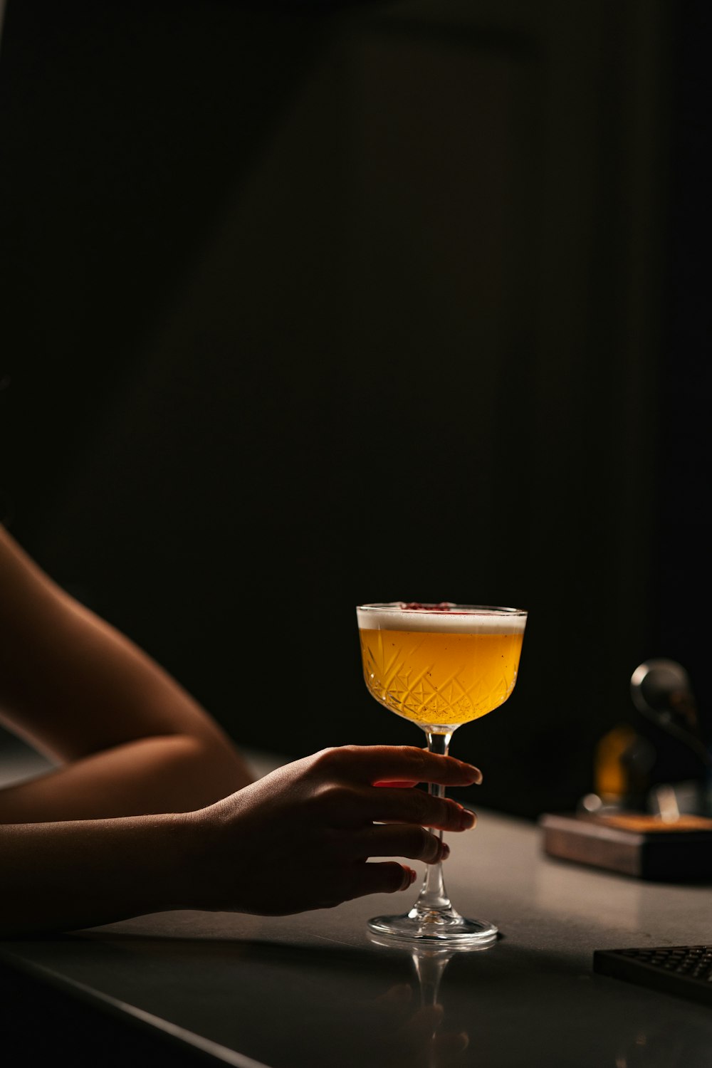 a person sitting at a table with a drink