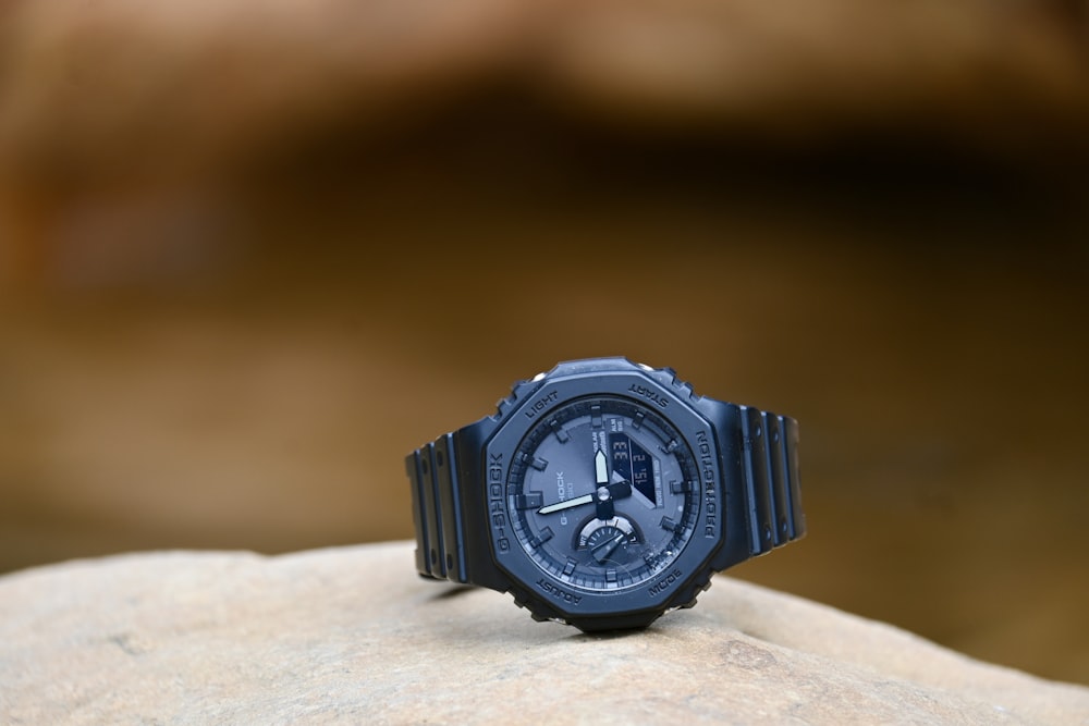 a watch sitting on top of a rock