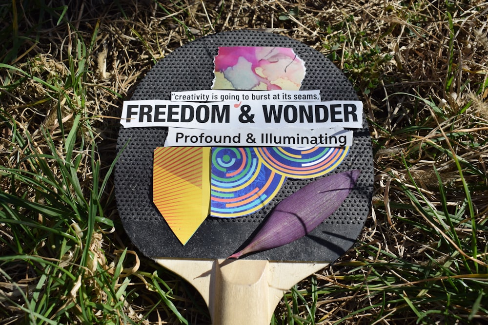 a wooden paddle on the ground with a sign on it