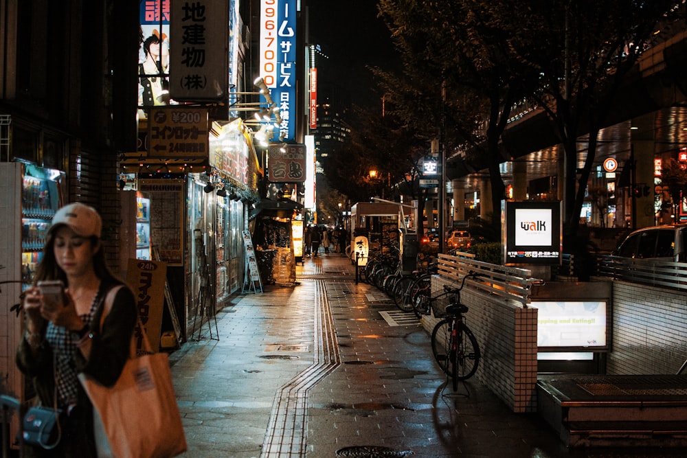 a woman walking down a street at night