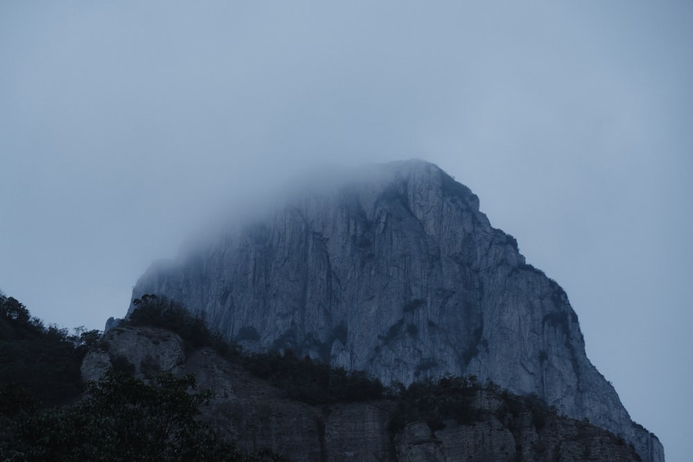 a very tall mountain with a very low hanging cloud