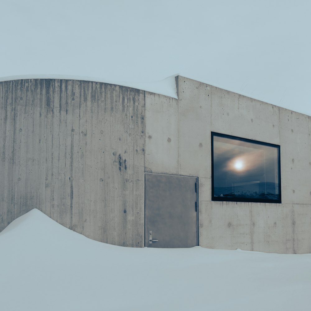 a building with a window and a door in the snow