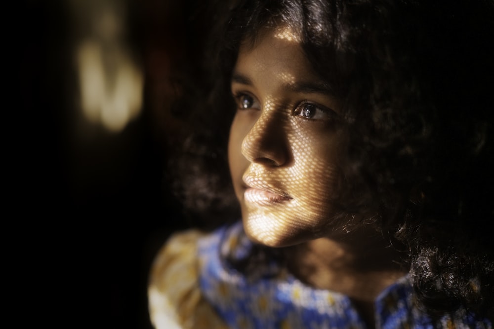 a close up of a young girl with curly hair