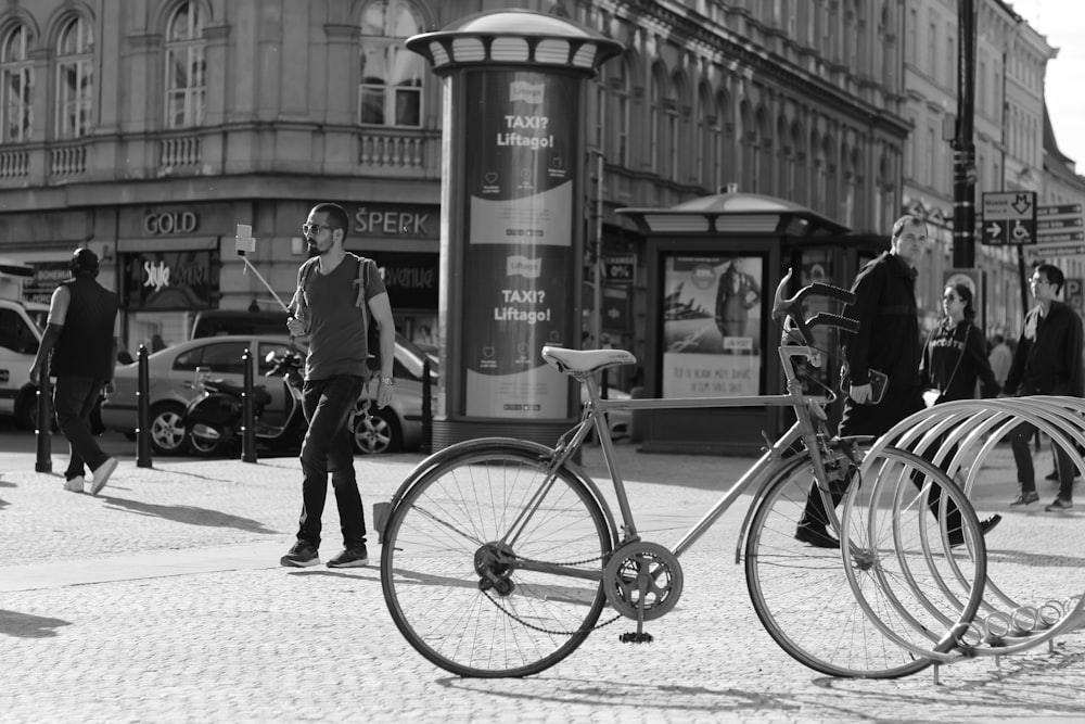 a man standing next to a bike on a street