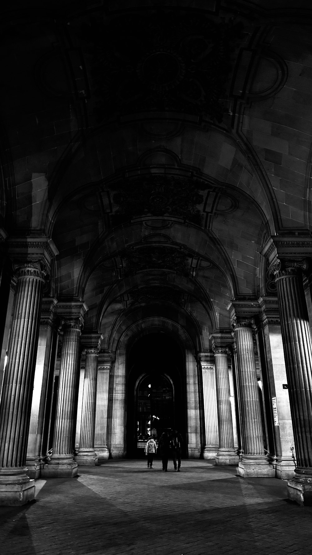 a black and white photo of two people standing in a building