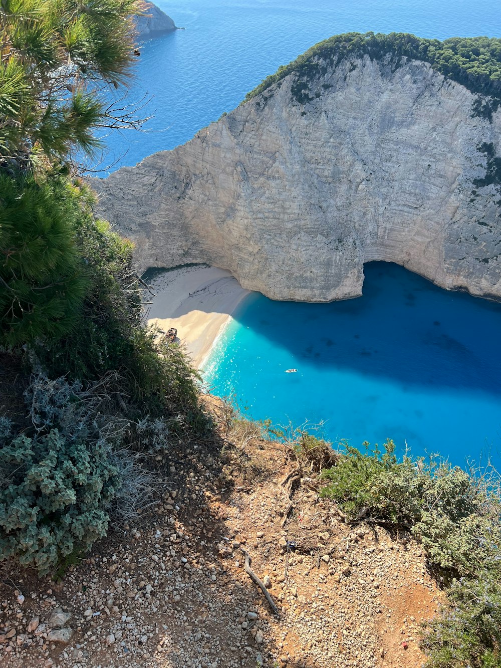 un grande specchio d'acqua seduto accanto a una collina verde lussureggiante