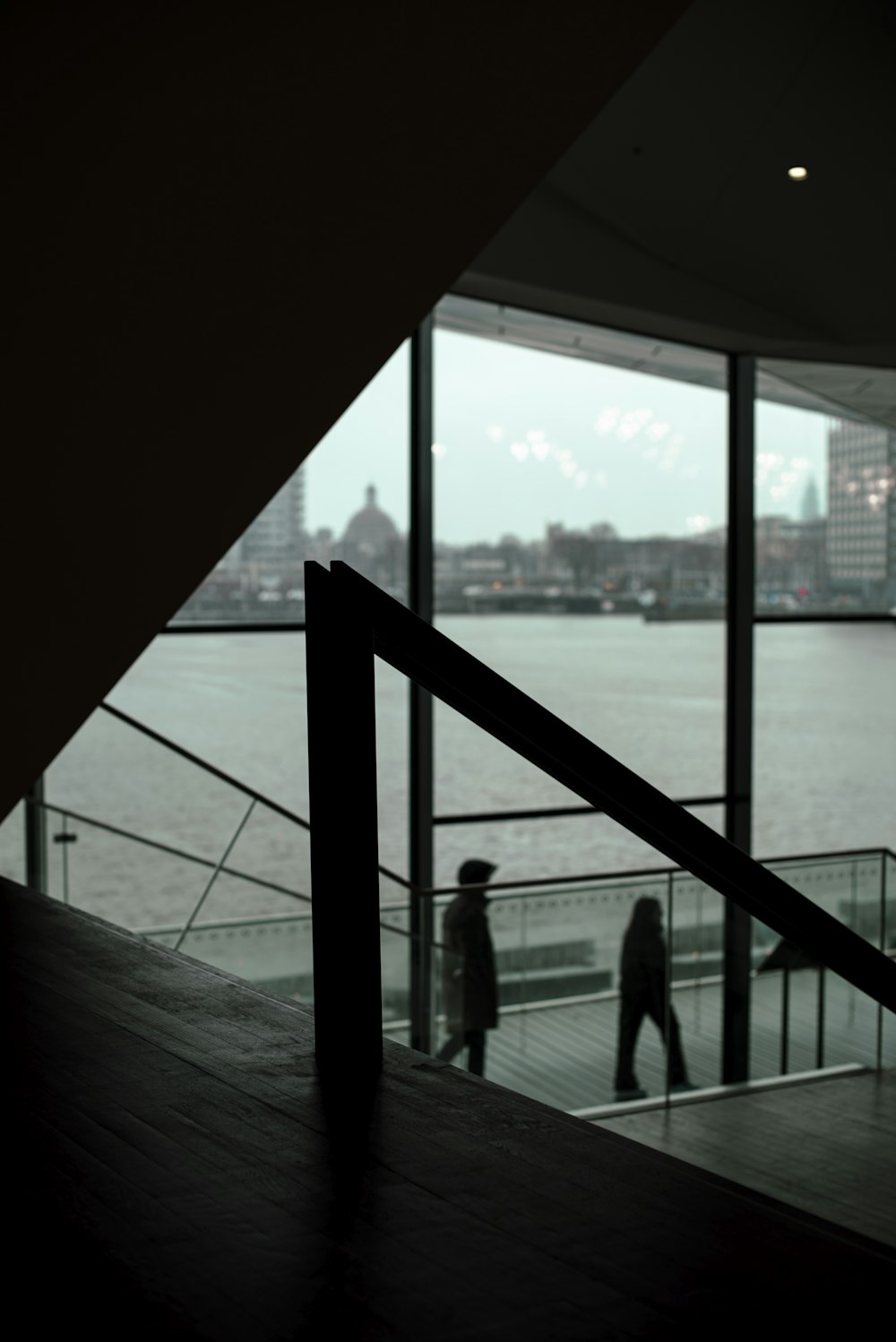 a man walking up a flight of stairs next to a body of water