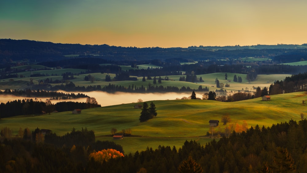 une vue panoramique d’une vallée avec du brouillard au loin