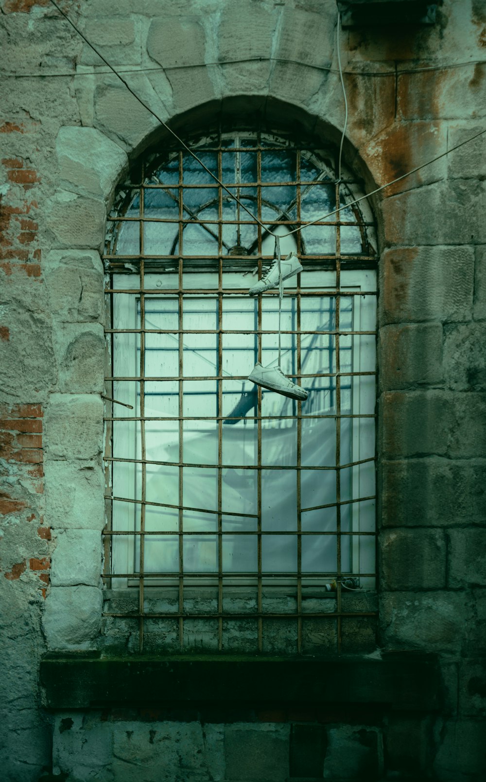 a window in a brick wall with bars on it