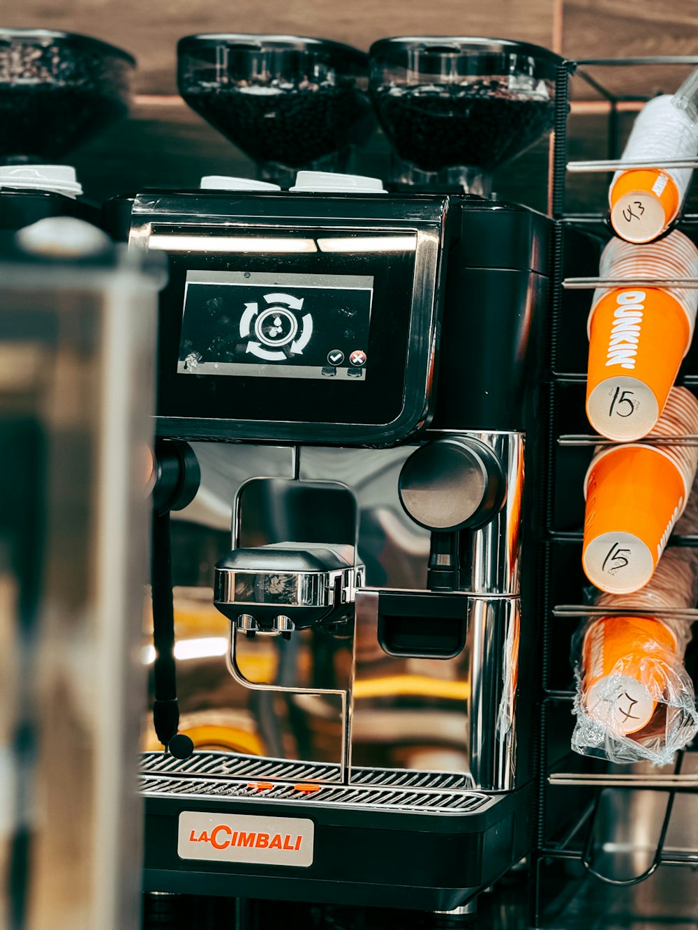 an espresso machine with orange cups on it