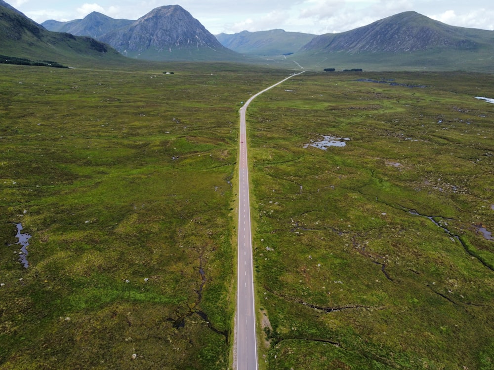 an aerial view of a road in the middle of a field