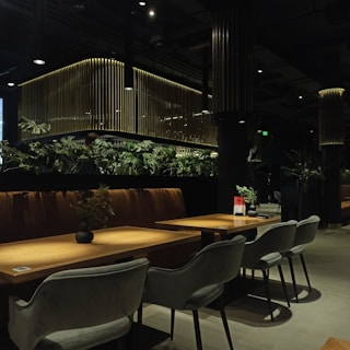 a restaurant with tables and chairs and plants on the wall