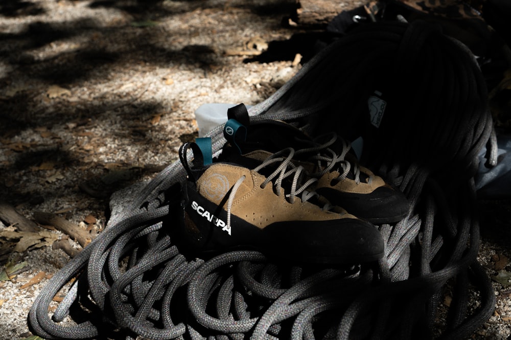 a pair of hiking shoes sitting on top of a pile of rope