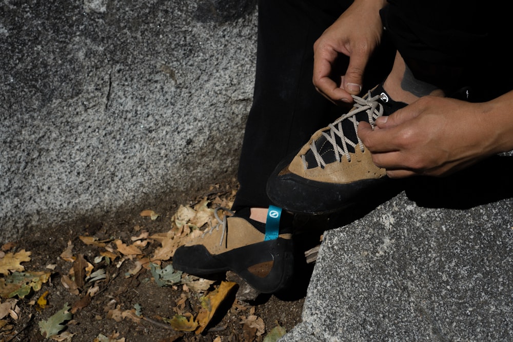 a person tying a shoelace to a pair of shoes