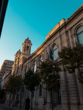 a man walking down a street next to a tall building