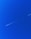 a jet flying through a blue sky with a contrail