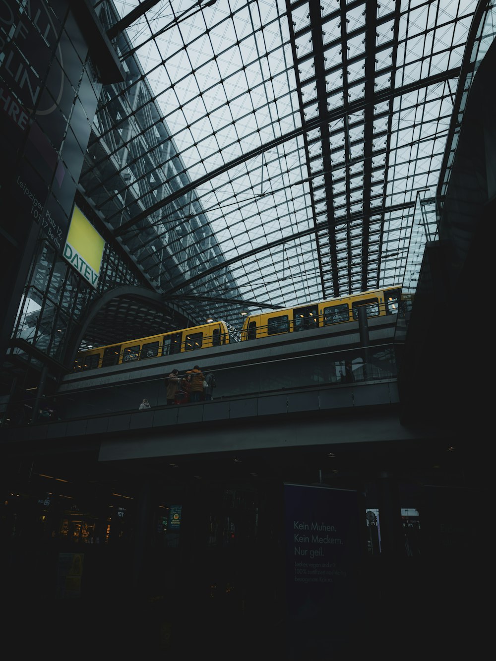 ein gelber Zug, der durch einen Bahnhof fährt