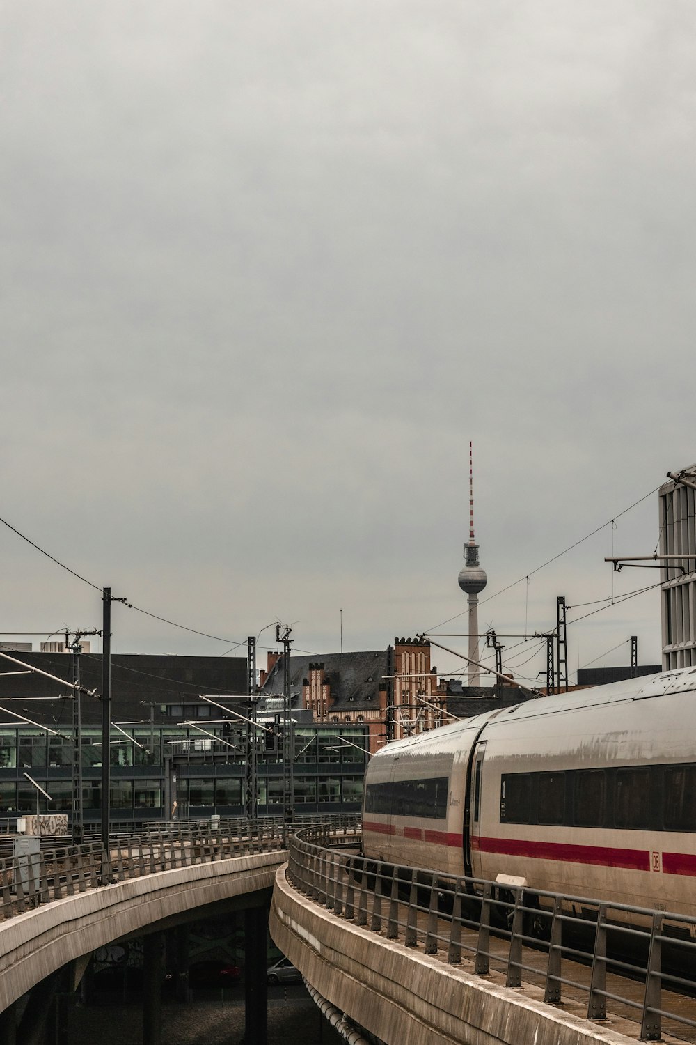 Ein Zug, der über eine Brücke neben einem hohen Gebäude fährt