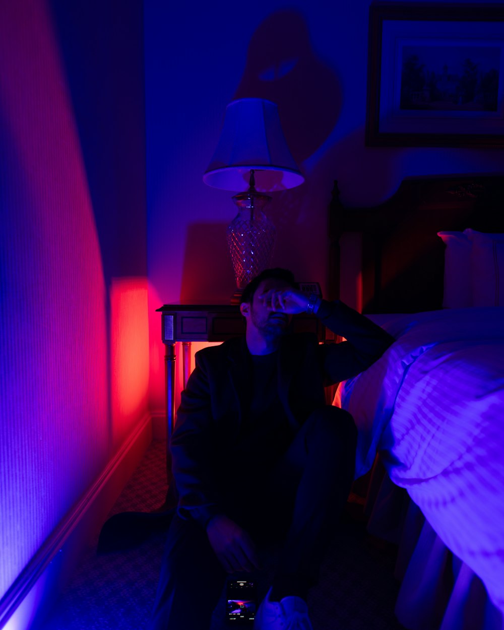 a man sitting on a bed in a dark room