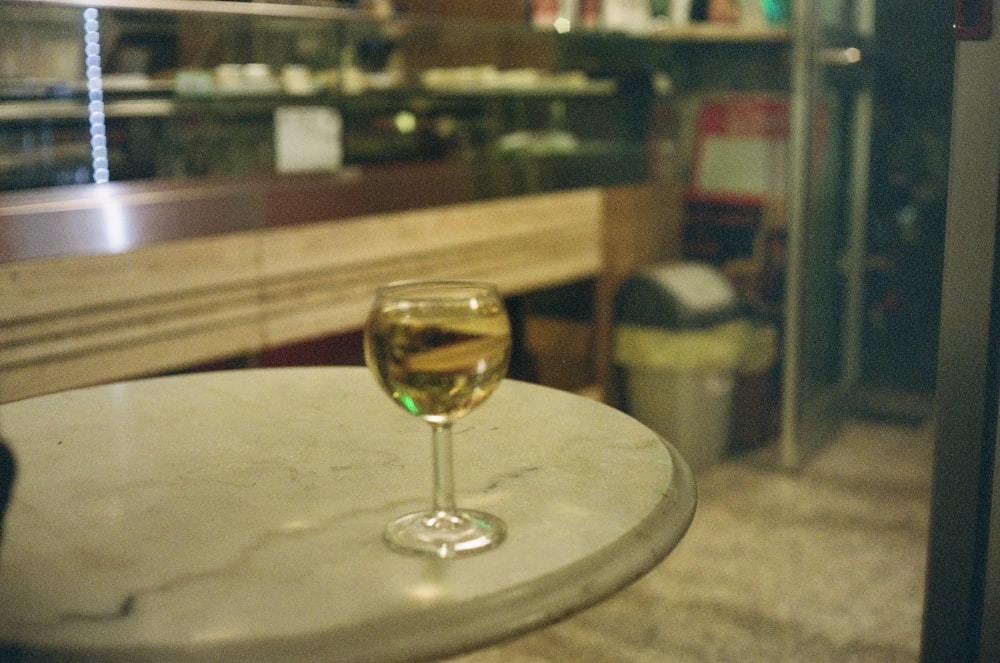 a glass of wine sitting on top of a table