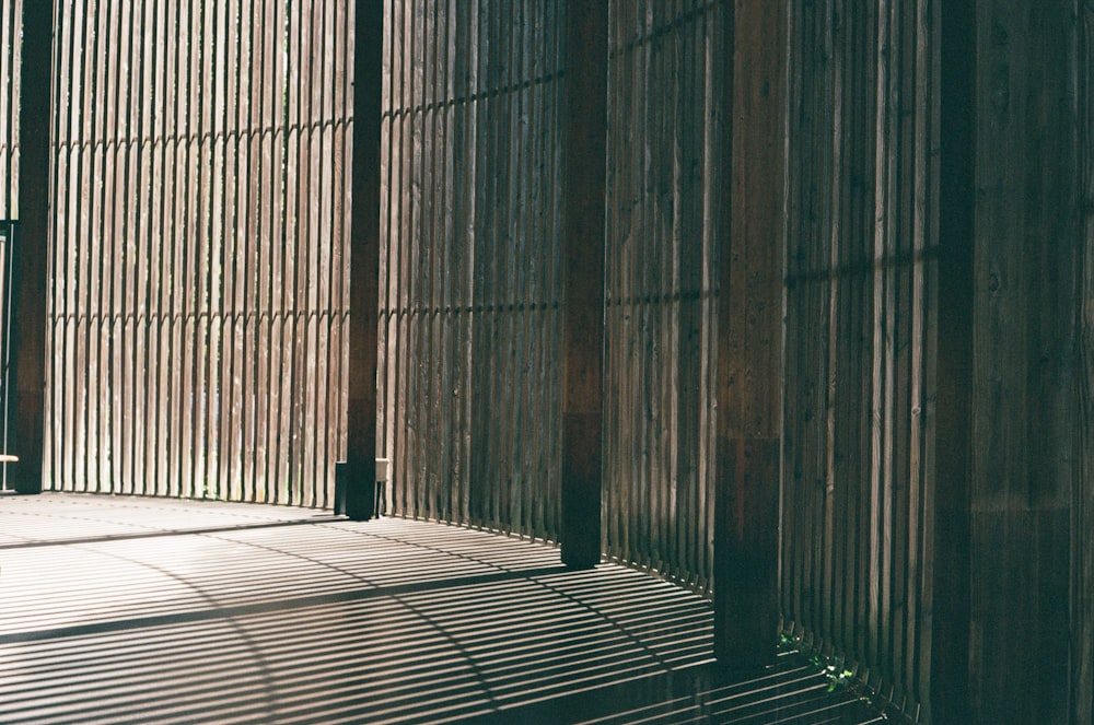 a bench sitting in front of a bamboo wall