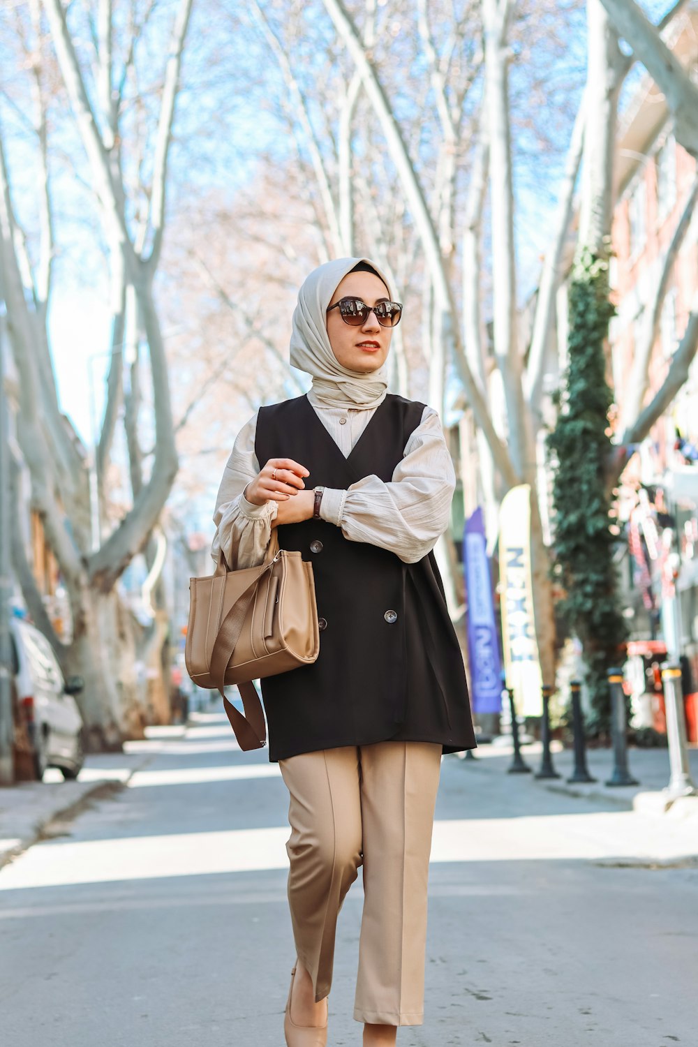 a woman in a hijab is walking down the street