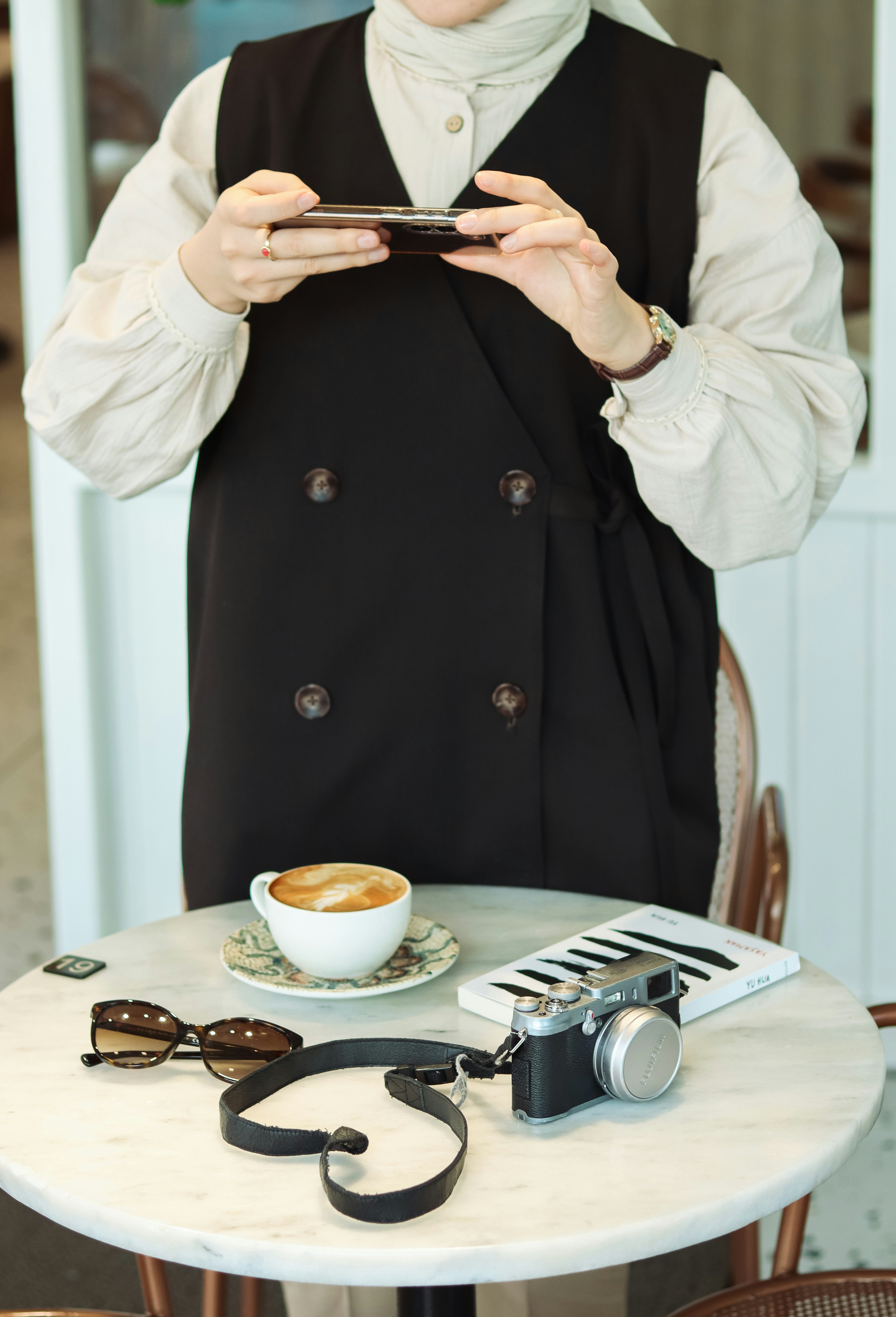 a person sitting at a table using a cell phone
