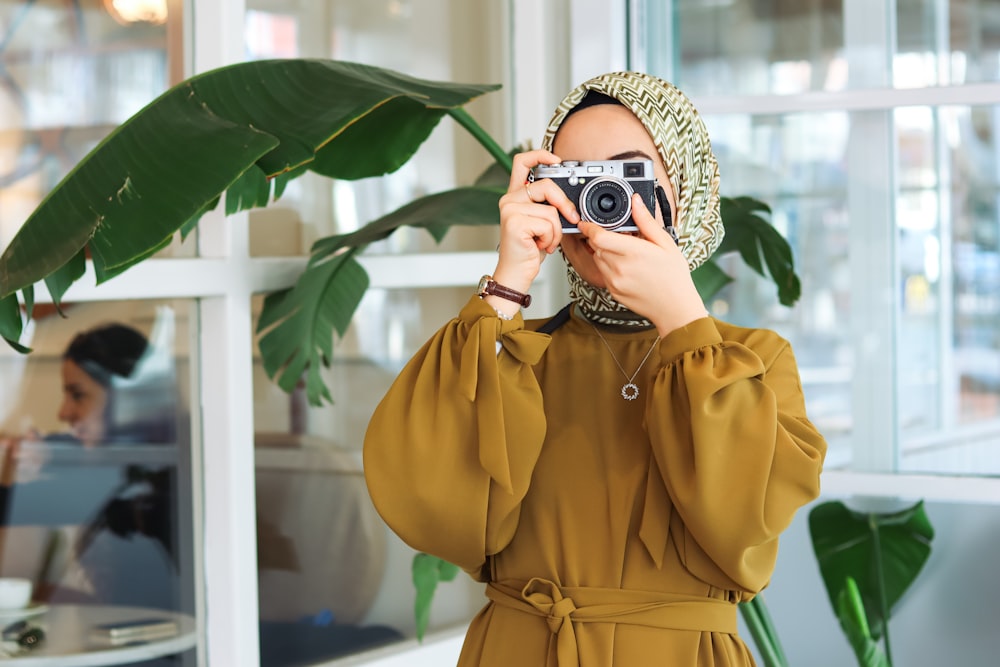 a woman taking a picture of herself with a camera