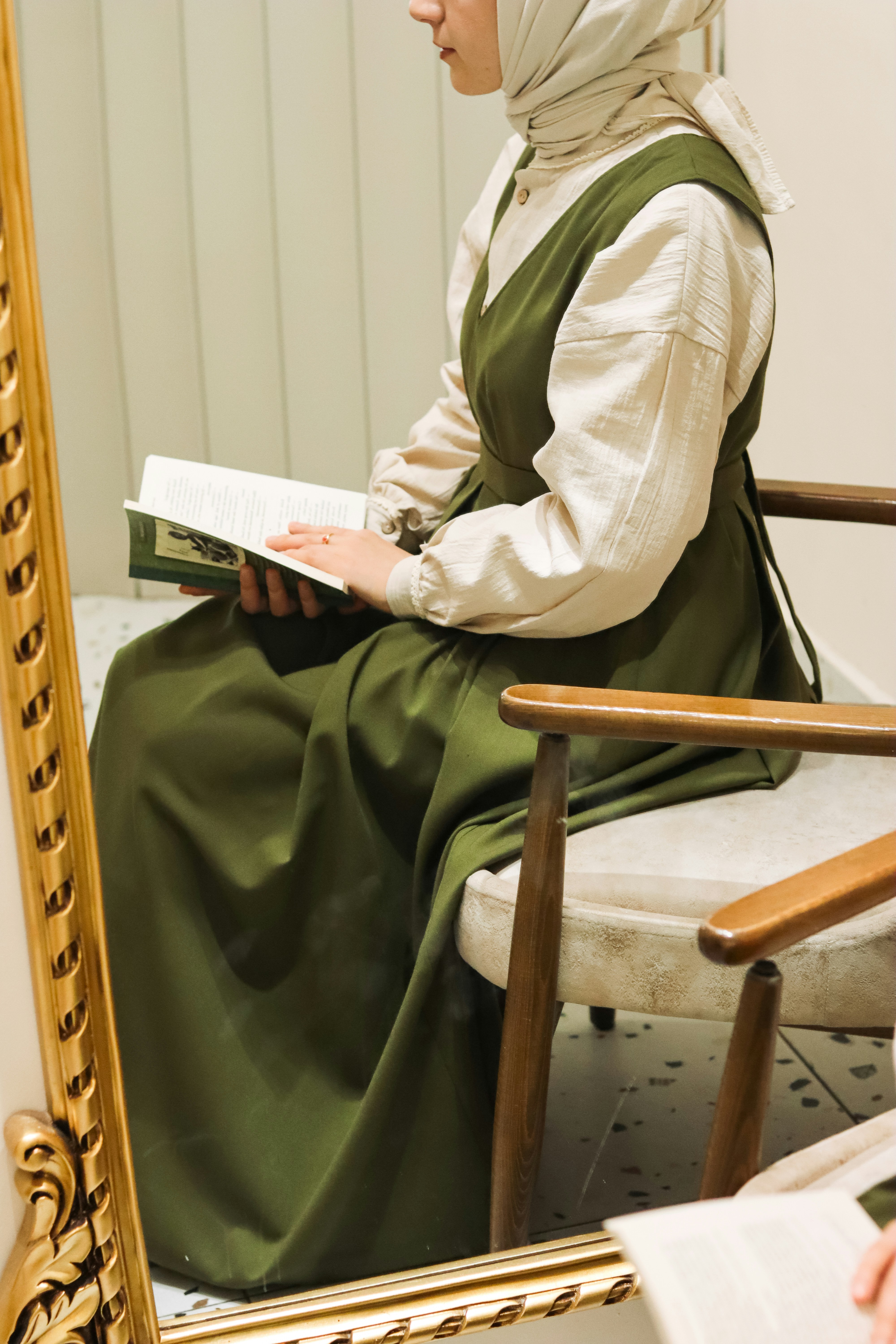 a woman sitting in a chair reading a book