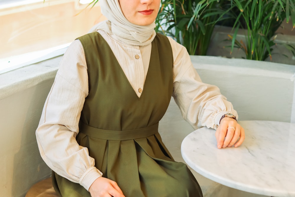 a woman wearing a hijab sitting at a table
