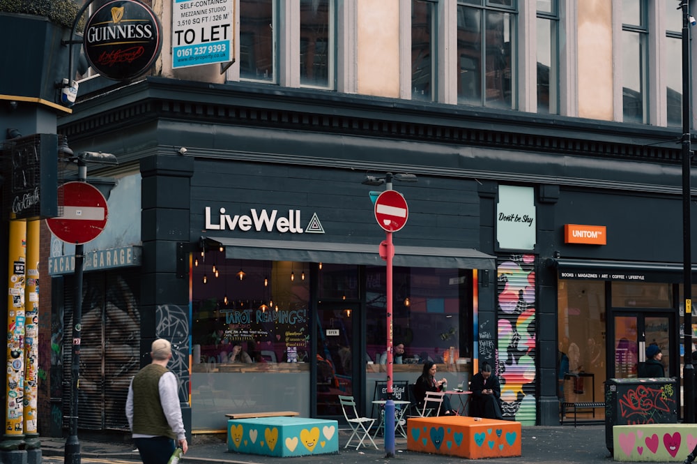 a man walking down a street past a store