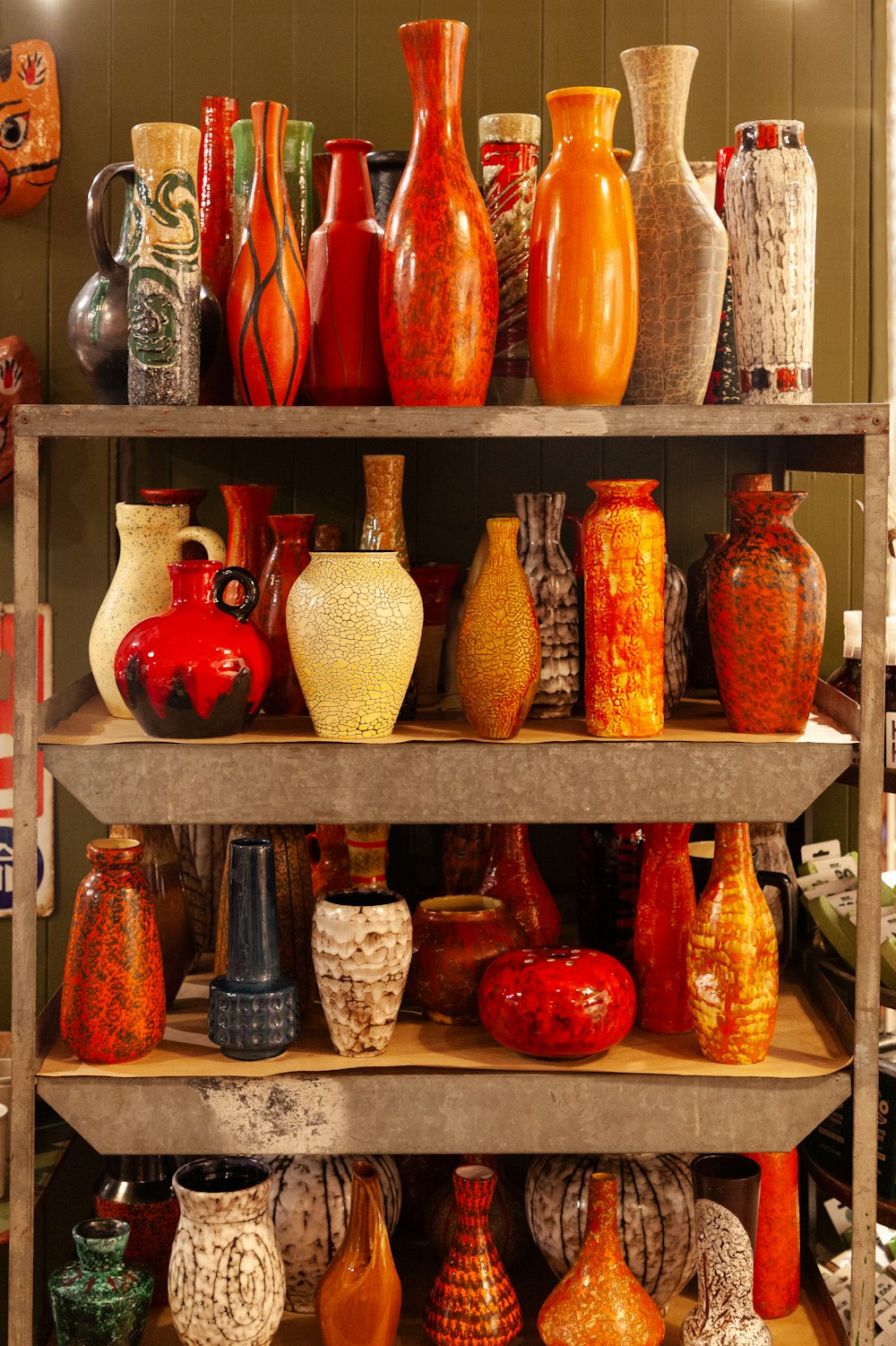 a shelf filled with lots of different colored vases