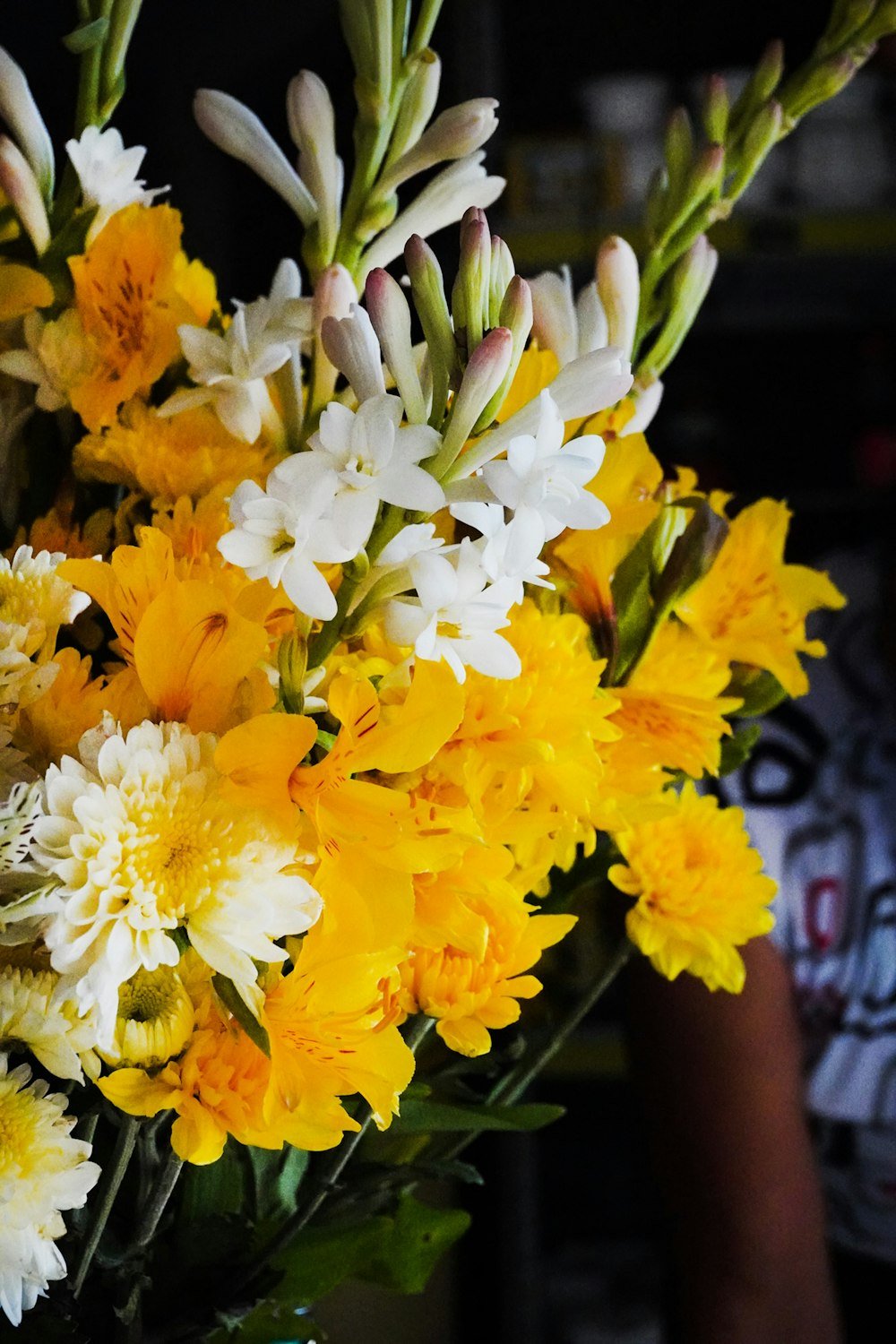 a vase filled with yellow and white flowers