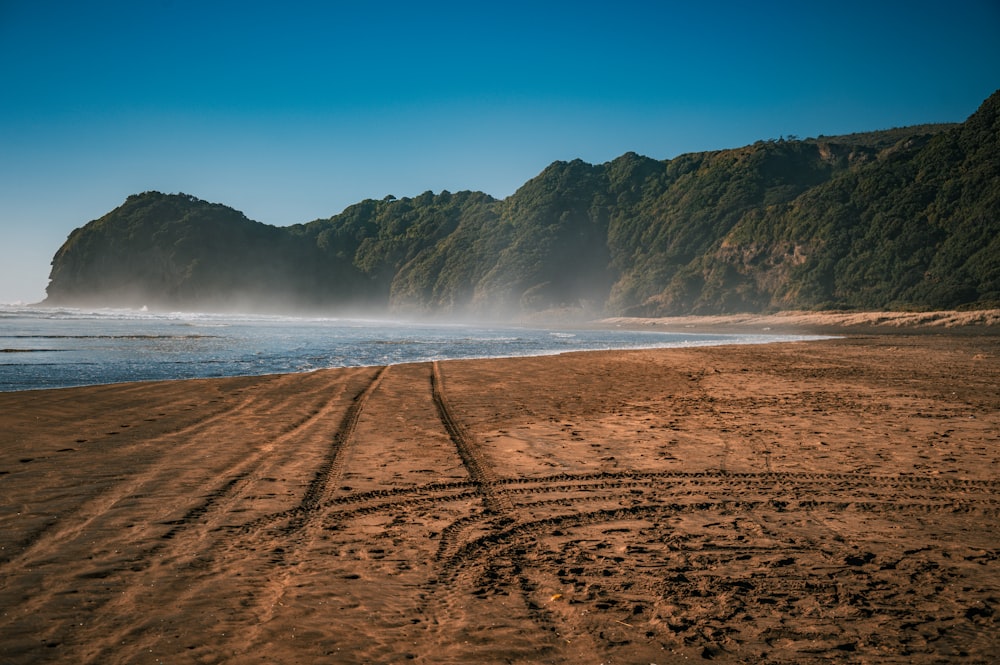 una playa de arena con una montaña al fondo