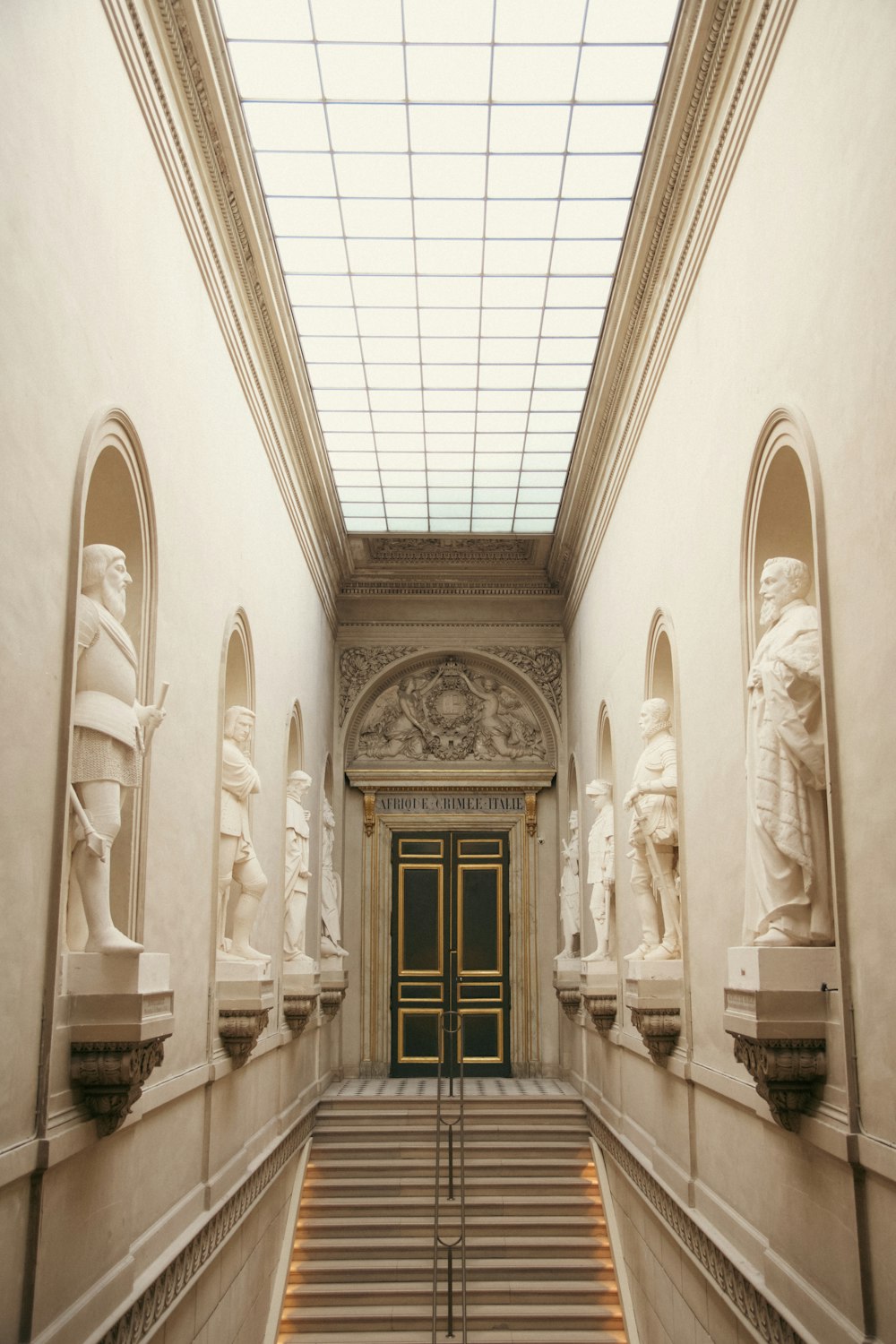 a very long hallway with some statues on the walls