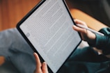 a person holding a tablet with a pen in their hand