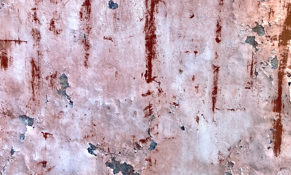 a red and white wall with peeling paint
