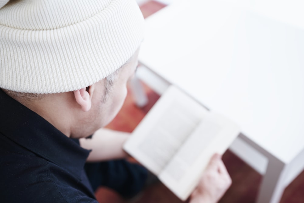 a man sitting at a table reading a book