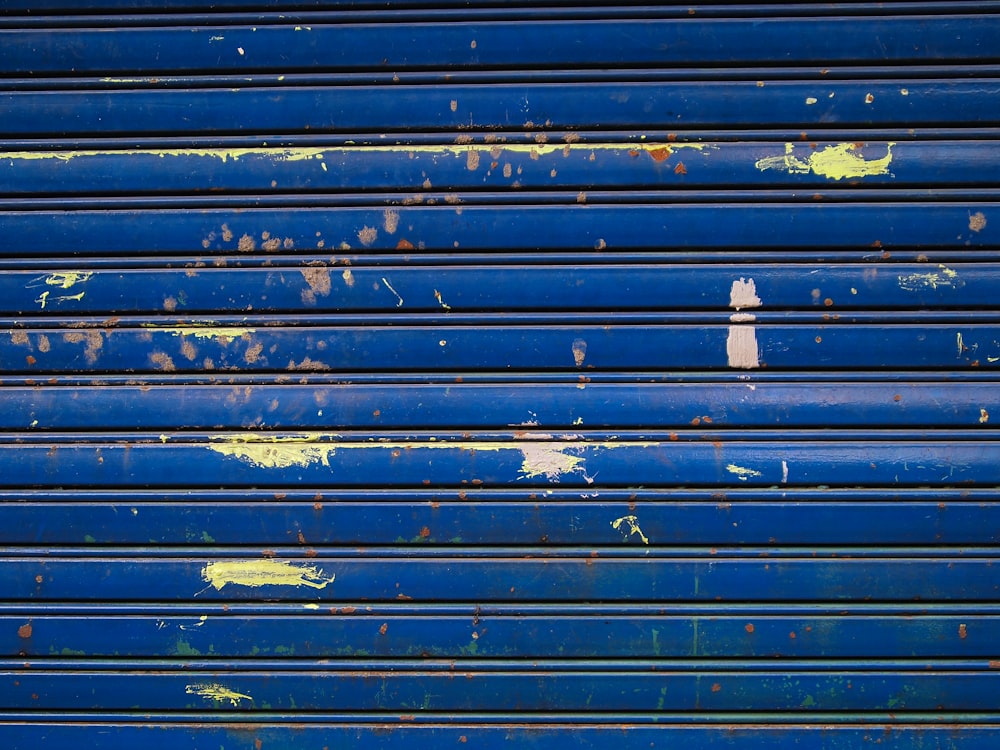 a close up of a blue metal door with peeling paint