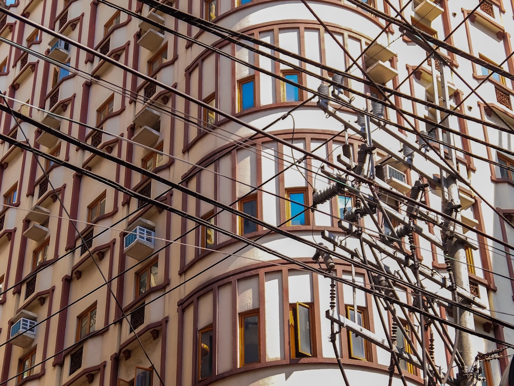 a tall building with lots of windows and power lines in front of it