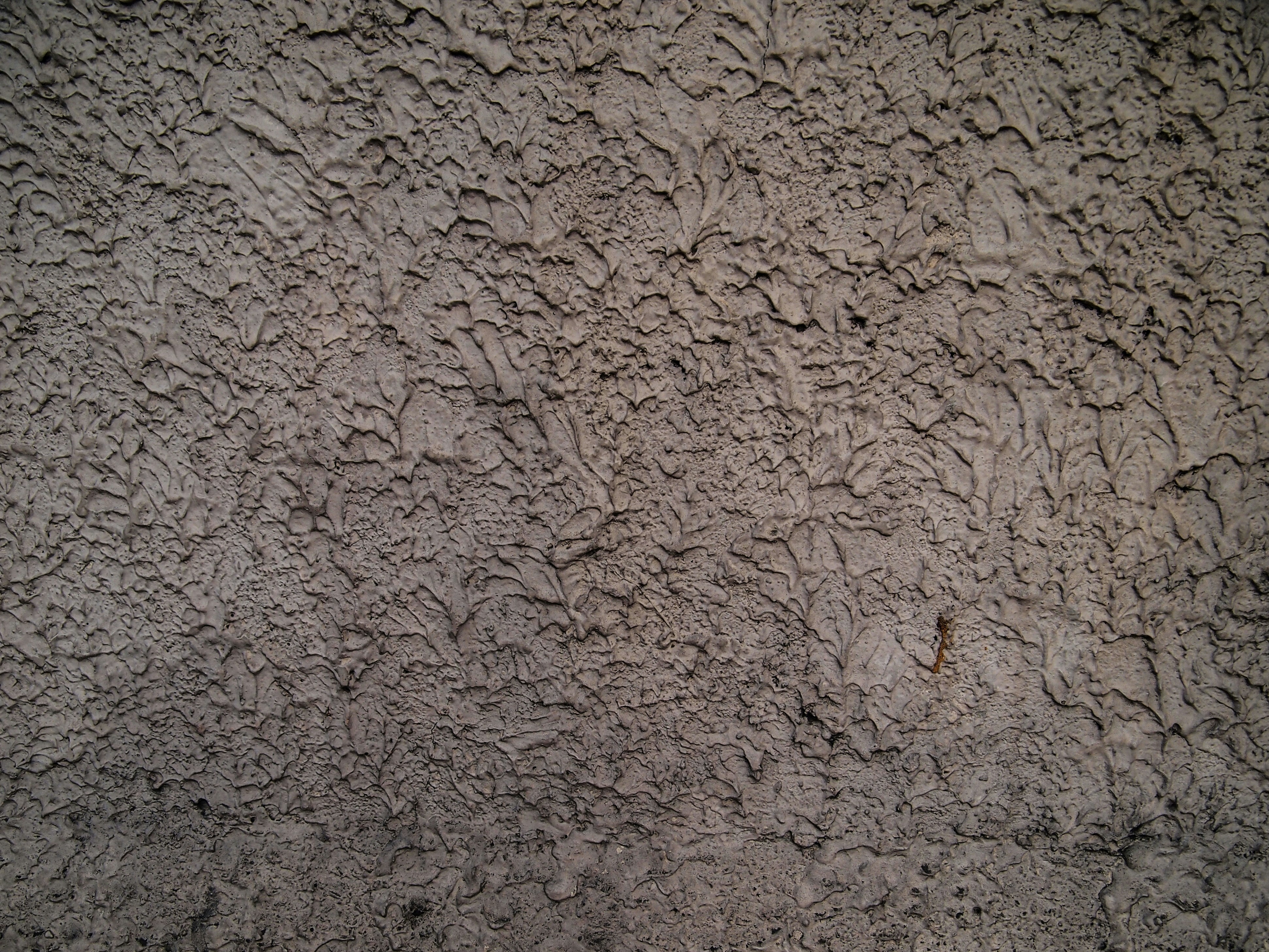 a close up of a cement wall with a red fire hydrant