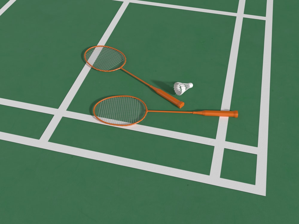 two tennis rackets laying on a tennis court