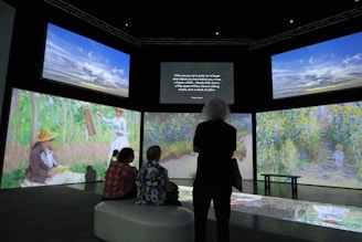 a group of people standing in front of a display of paintings