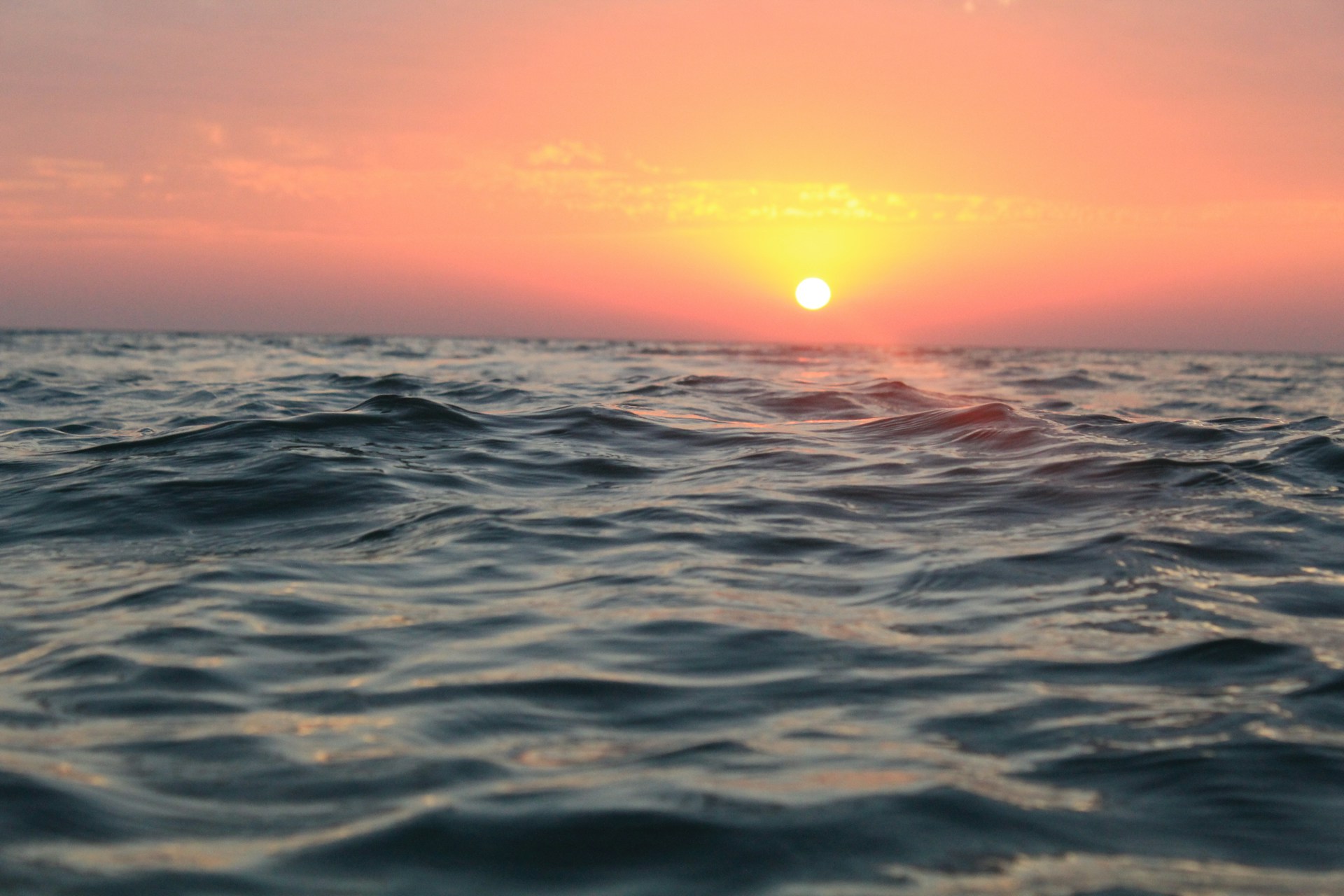 the sun is setting over the ocean water