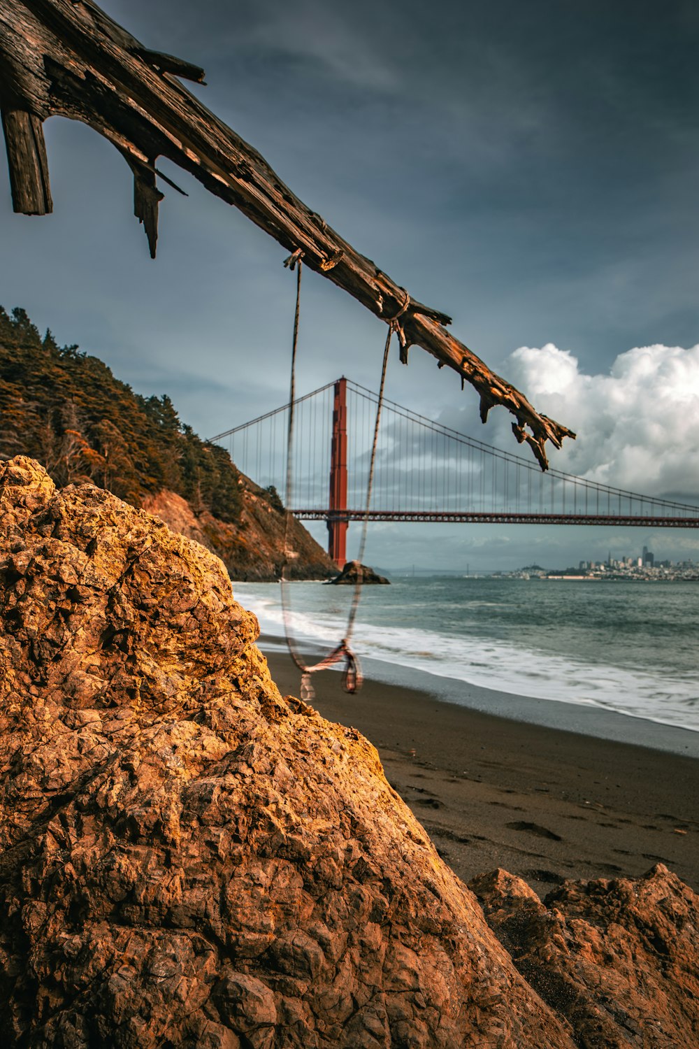 a person hanging from a rope near the ocean