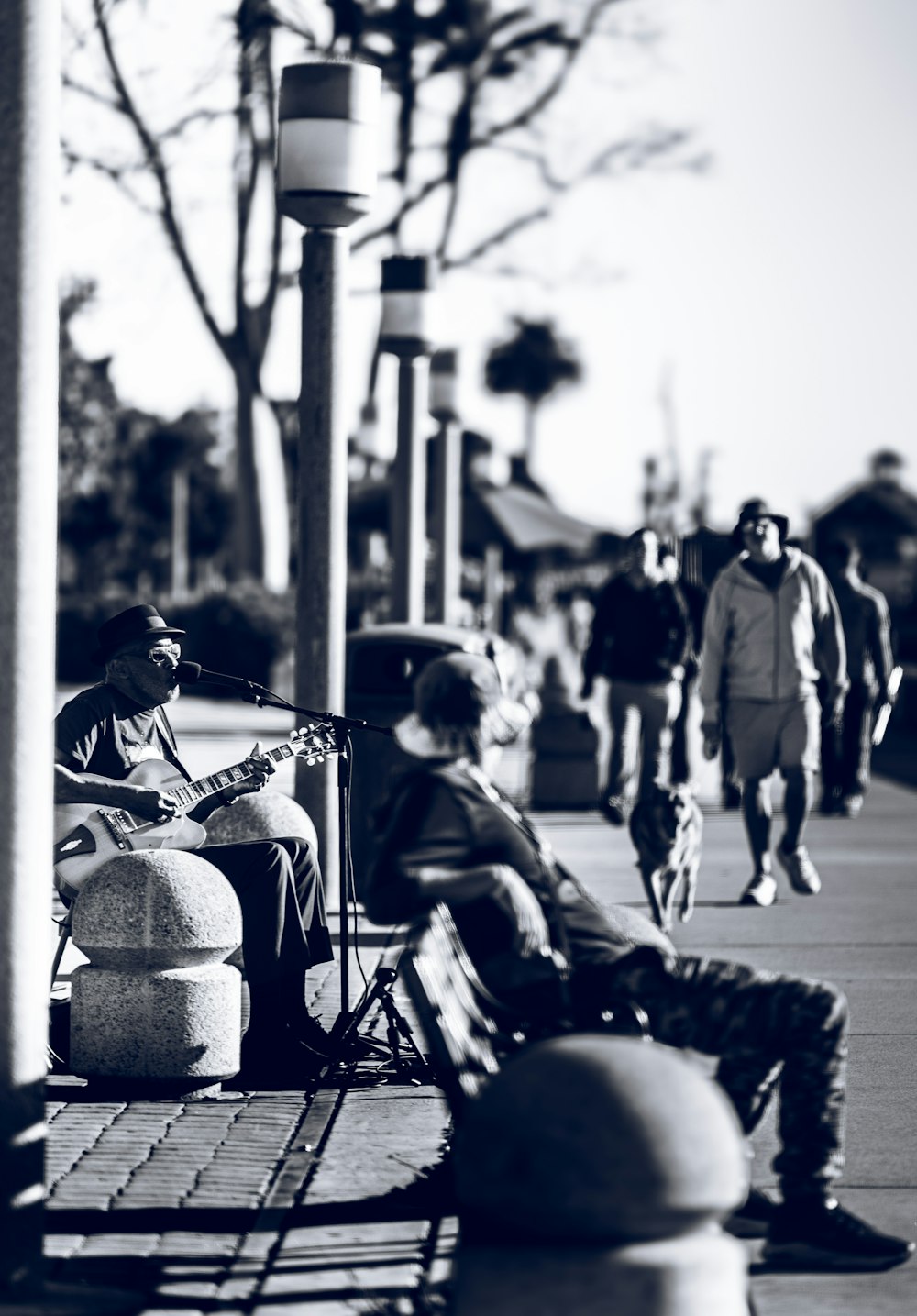 a man sitting on a bench next to a person on a skateboard