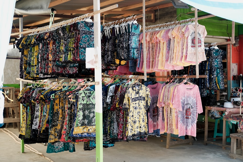 a woman is looking at a display of shirts