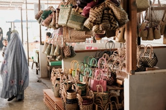 a woman standing in front of a store filled with baskets